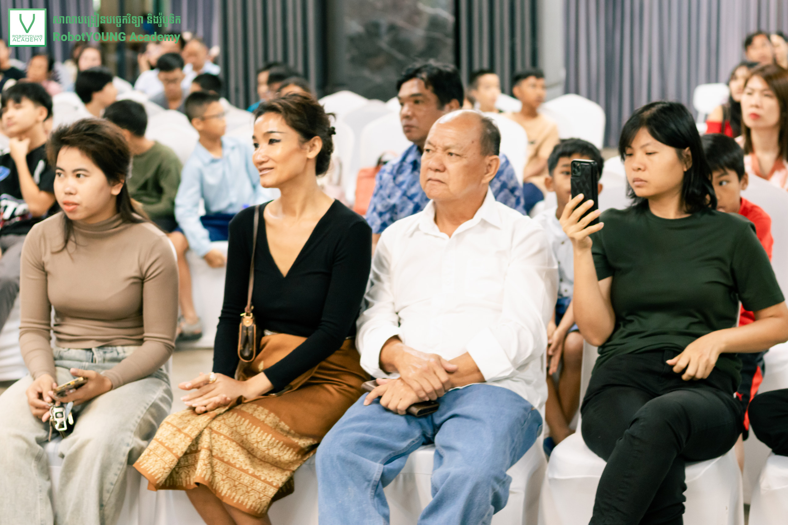 Adults and children attending an indoor RobotYOUNG Academy event