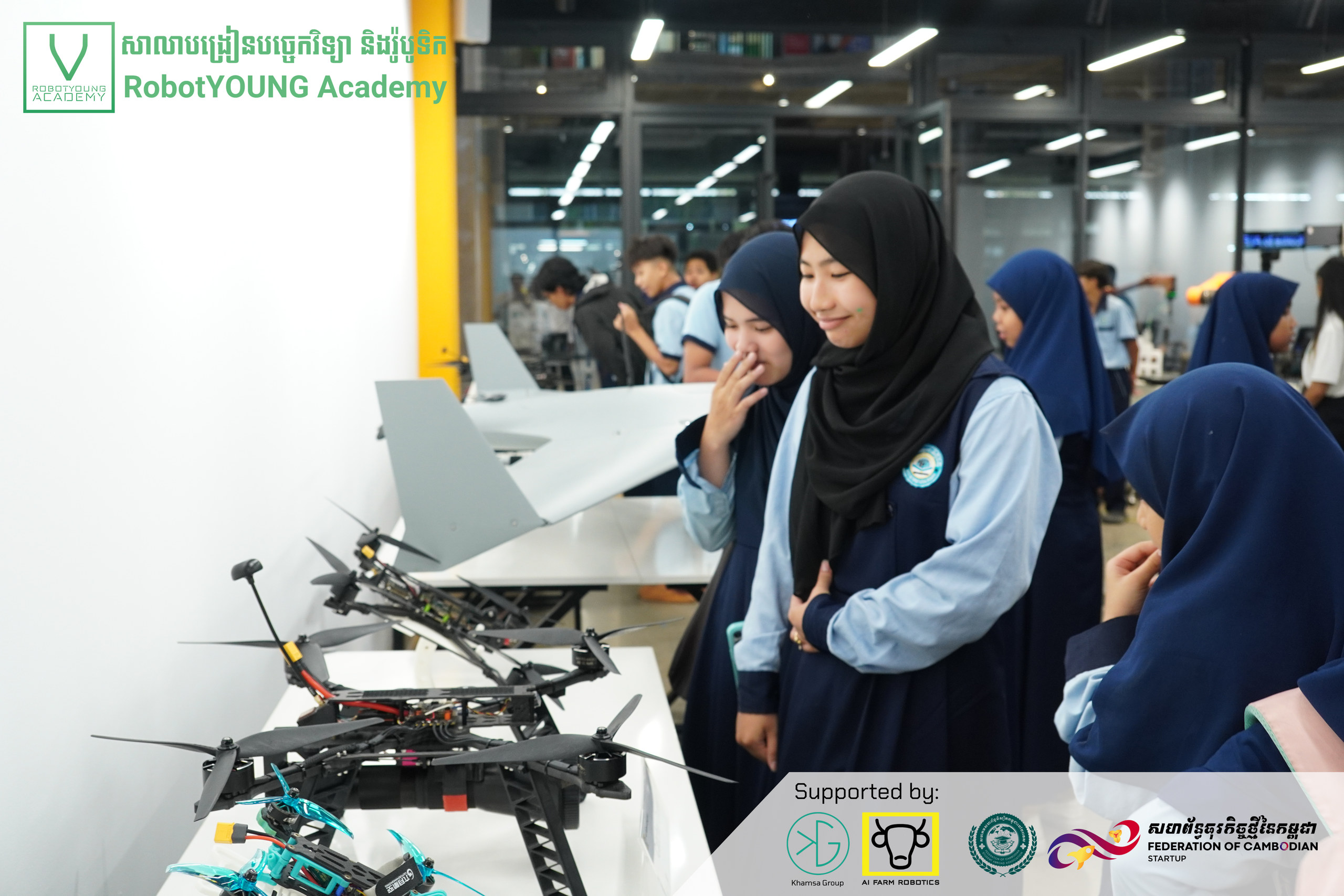 Illustrative academy photo of visitors examining large multirotor drones