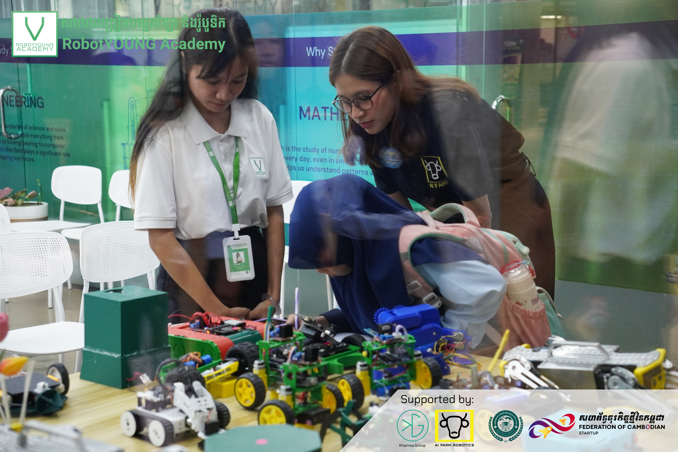 Visitors examining wheeled robot models on a display table